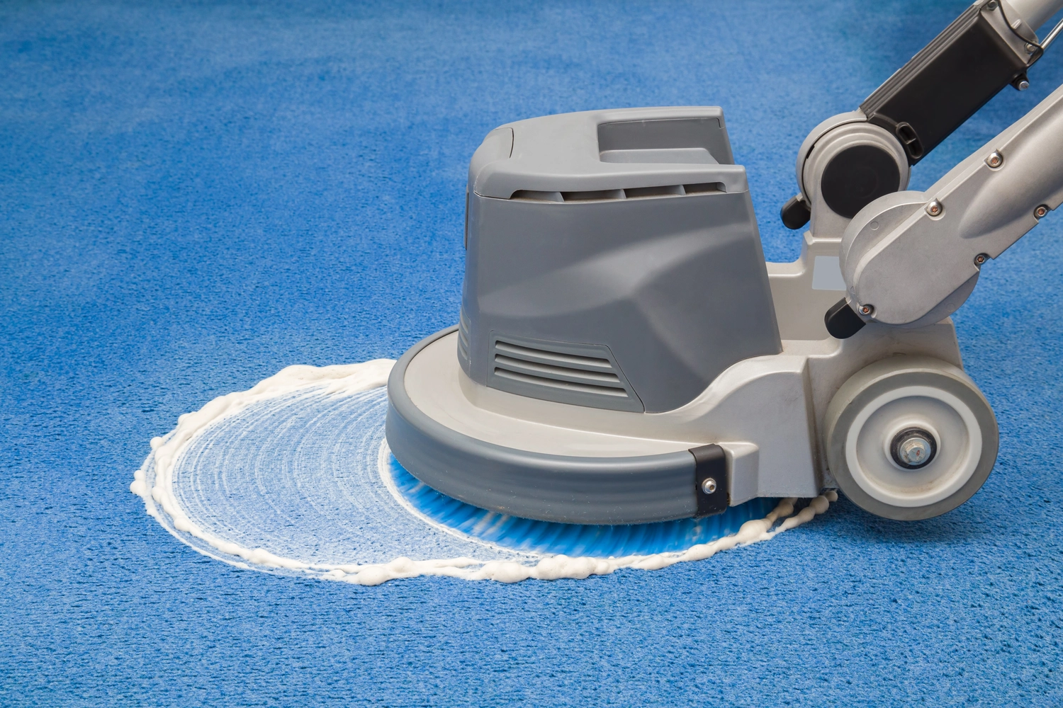 OLAG Gebäudeservice - Reinigungsfirma - Chemische Schaumreinigung, Reiben und professionelle Reinigung blauer Teppiche mit einer Scheibenwaschmaschine. Regelmäßige Frühjahrsreinigung. Reinigungsservice-Konzept.